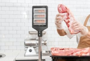 Incognito male butcher demonstrating meat