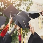 A group of graduates throwing graduation caps in the air